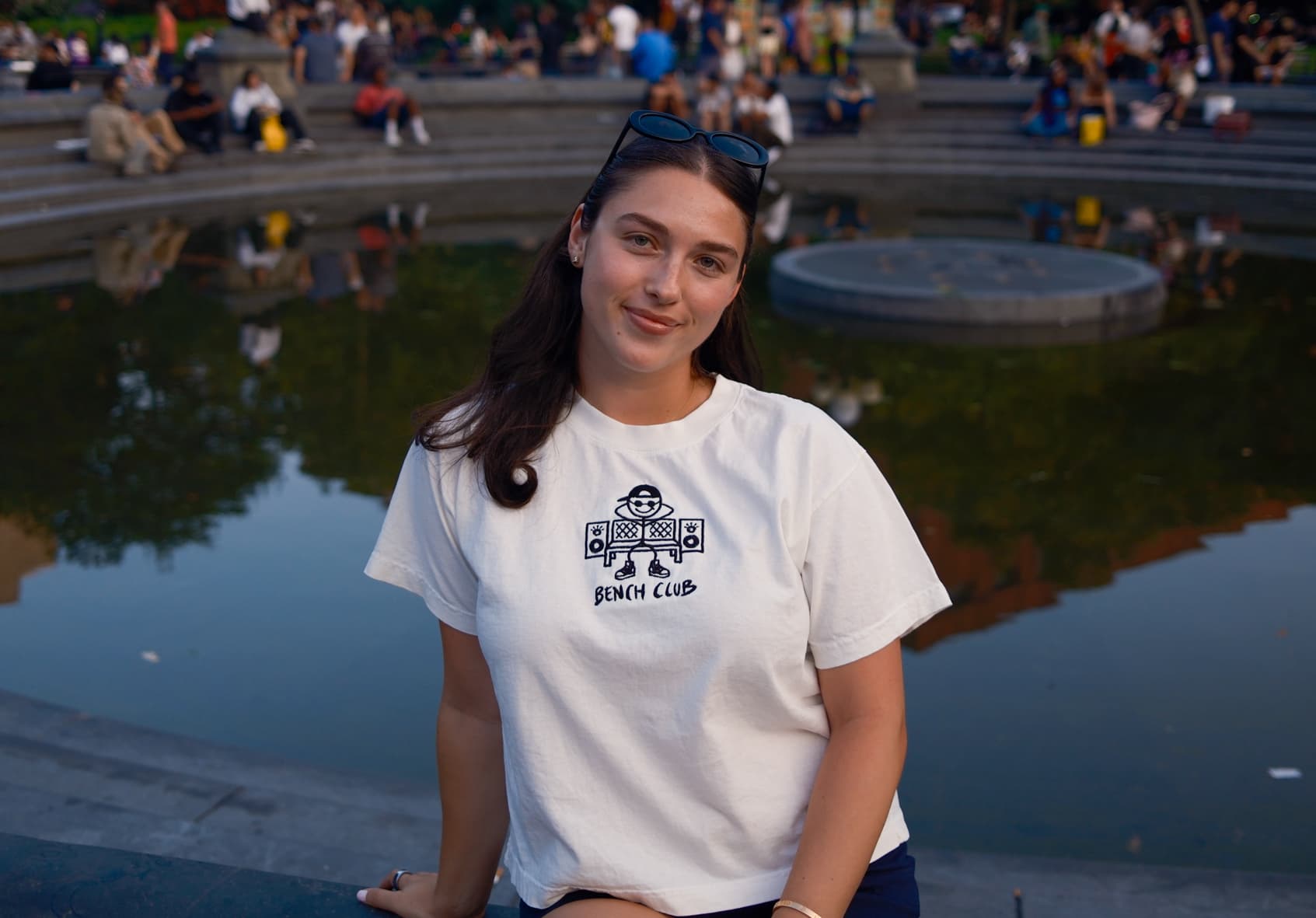 Woman in a white Bench Club tee at the Washington Square Park fountain
